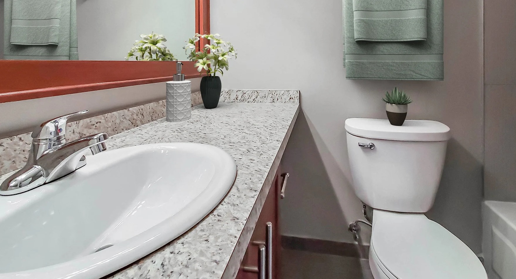 Contemporary bathroom with a granite vanity and a spacious mirror at Axis Apartments & Lofts in Chicago