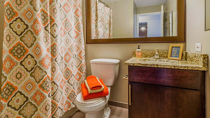 A modern bathroom at Axis Apartments & Lofts in Chicago, featuring a shower-tub combination and vanity