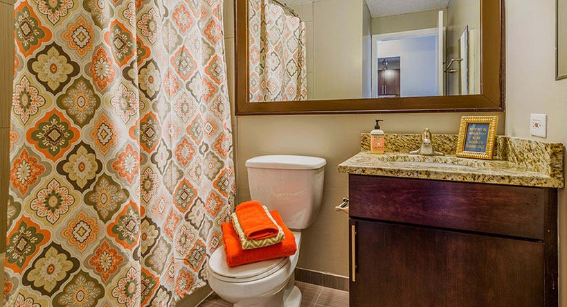 A modern bathroom at Axis Apartments & Lofts in Chicago, featuring a shower-tub combination and vanity