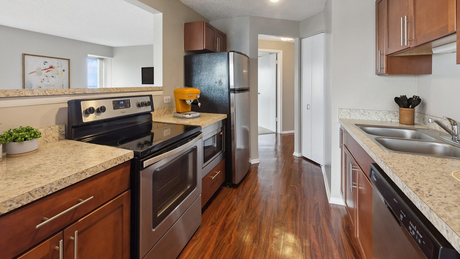 A functional galley kitchen with modern appliances and an open pass-through at Axis Apartments & Lofts in Chicago