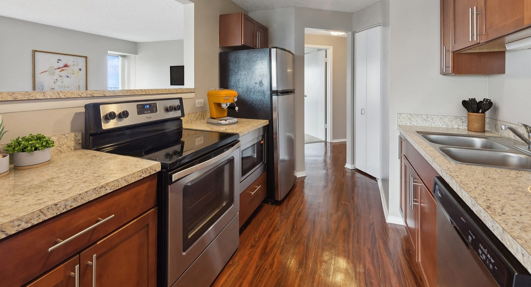 A functional galley kitchen with modern appliances and an open pass-through at Axis Apartments & Lofts in Chicago