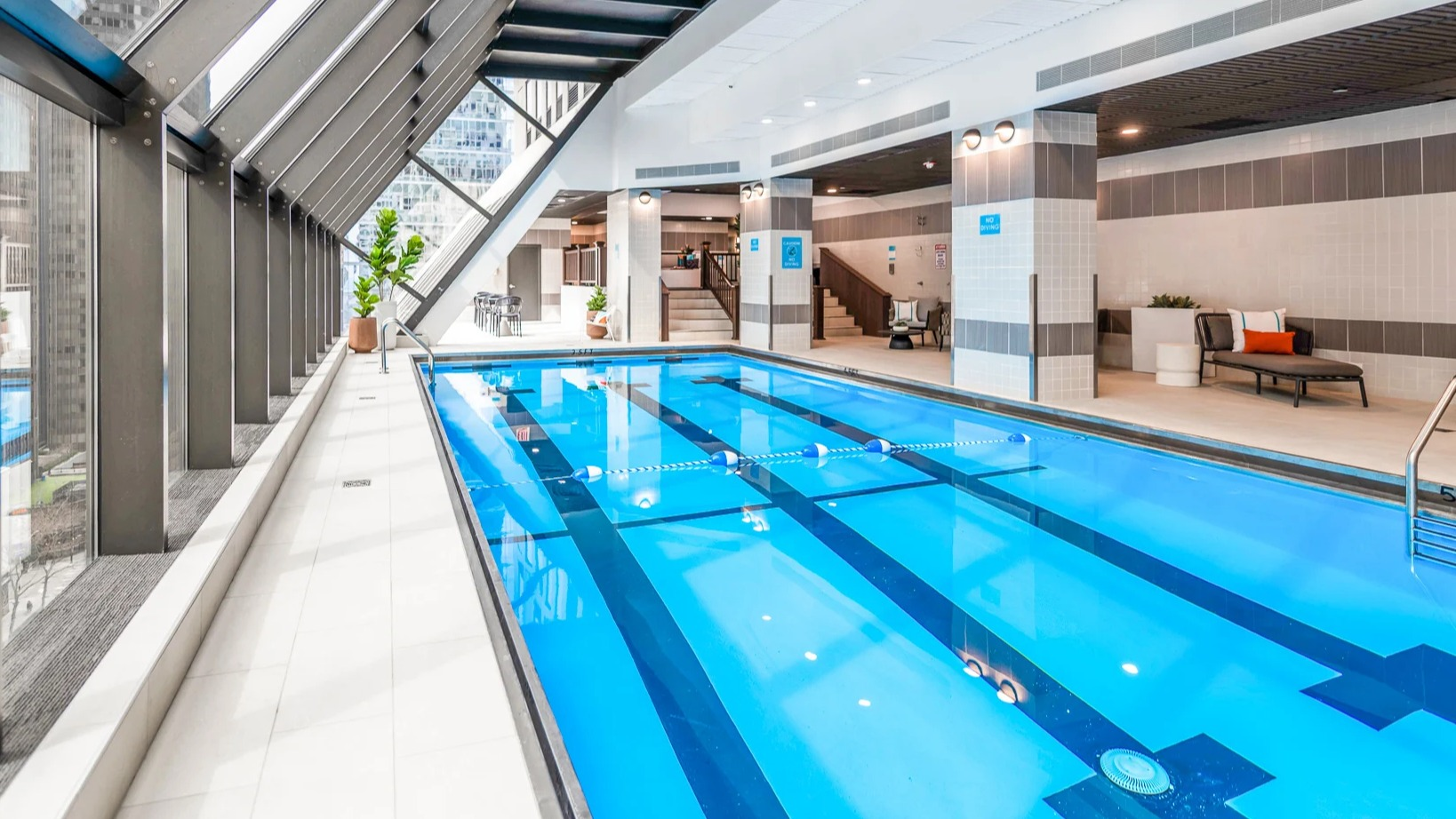 An inviting indoor swimming pool with natural light and city views at Axis Apartments & Lofts in Chicago