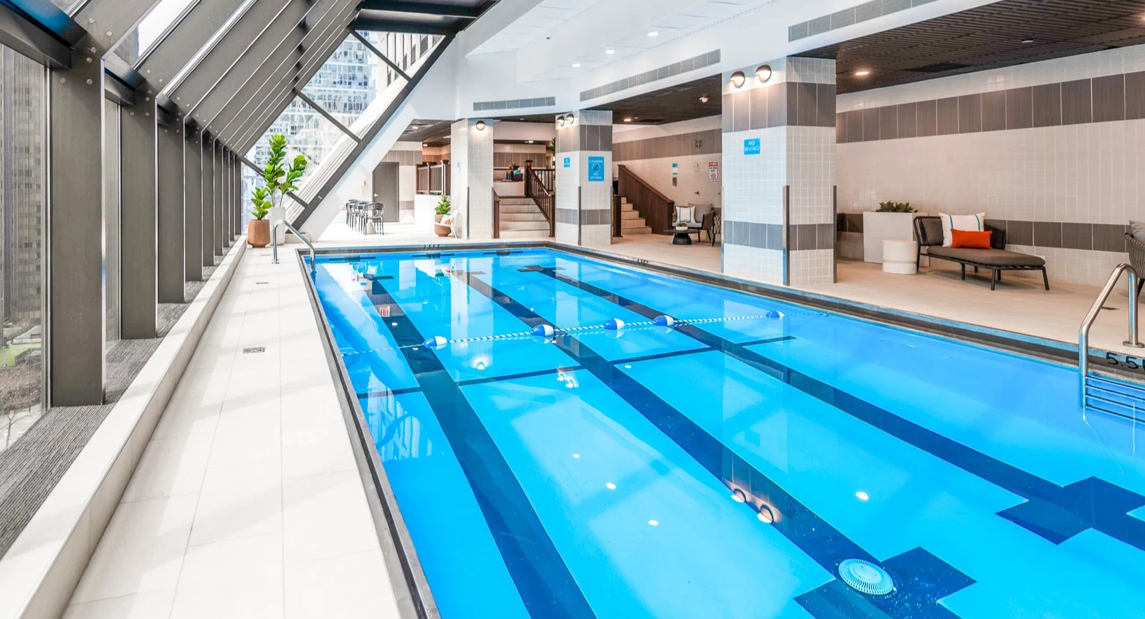 An inviting indoor swimming pool with natural light and city views at Axis Apartments & Lofts in Chicago