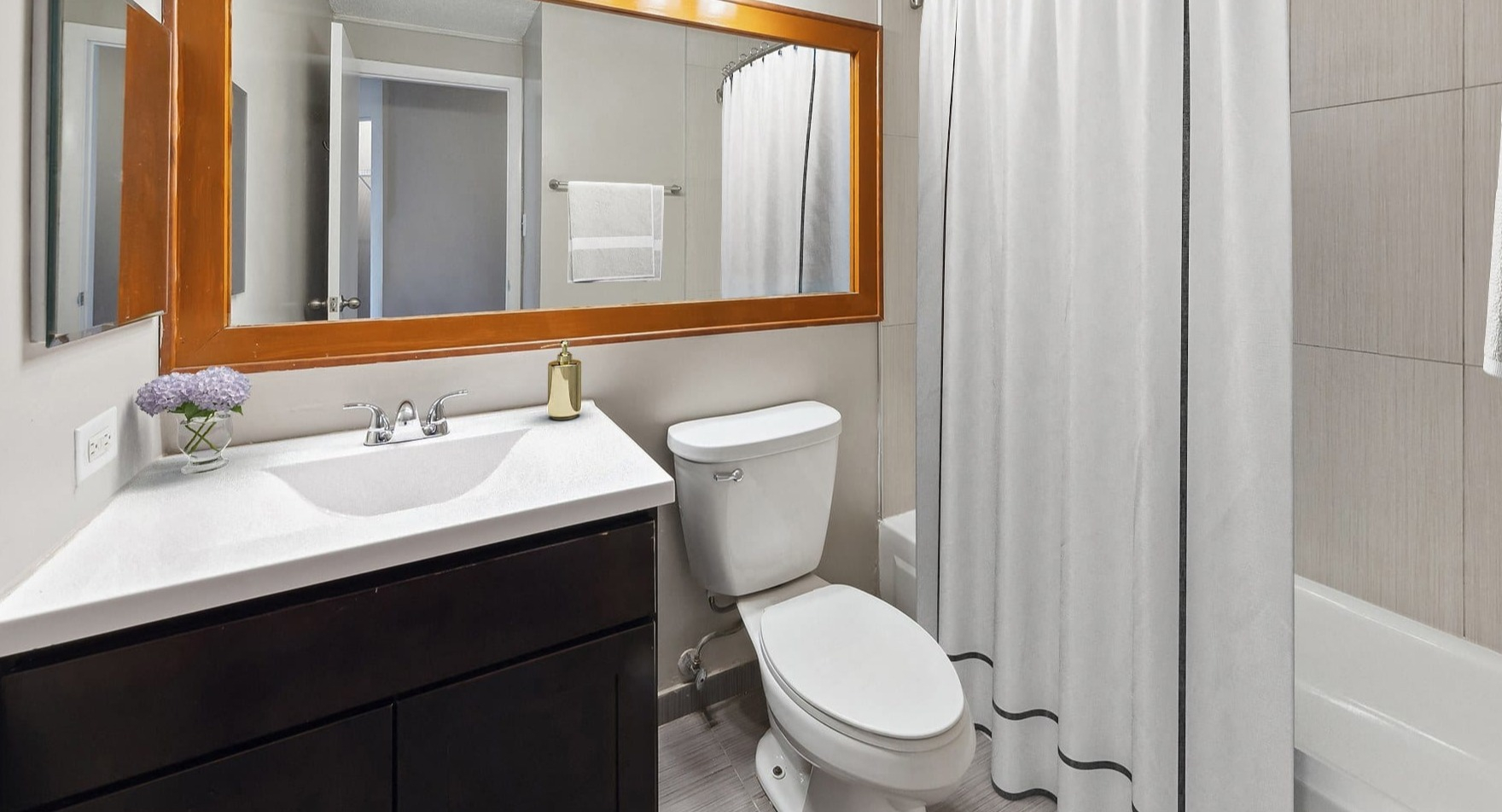 Modern bathroom with a shower-tub combo and sleek vanity at Axis Apartments & Lofts in Chicago