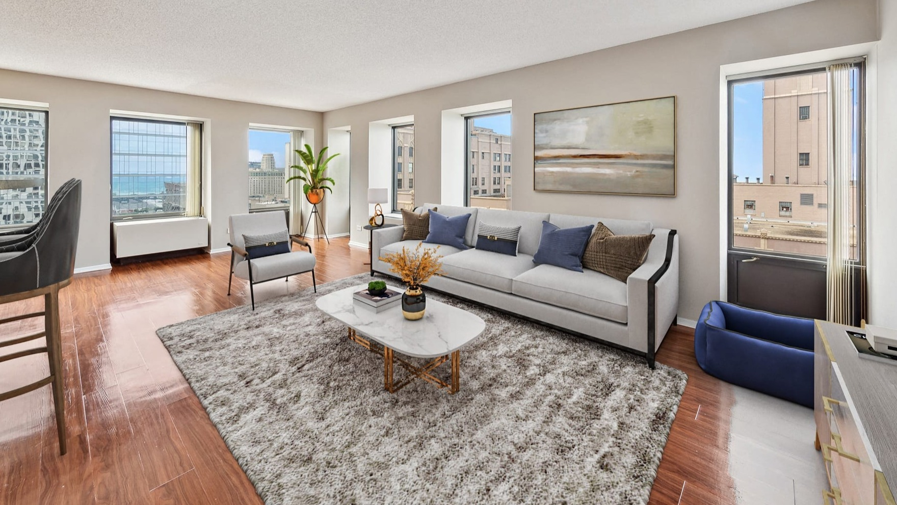 A spacious living room with large windows offering city views at Axis Apartments & Lofts in Chicago