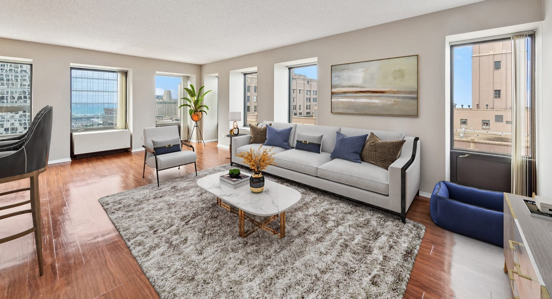A spacious living room with large windows offering city views at Axis Apartments & Lofts in Chicago