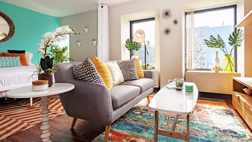 A stylish studio apartment at Axis Apartments & Lofts in Chicago, complete with a cozy living area and large windows
