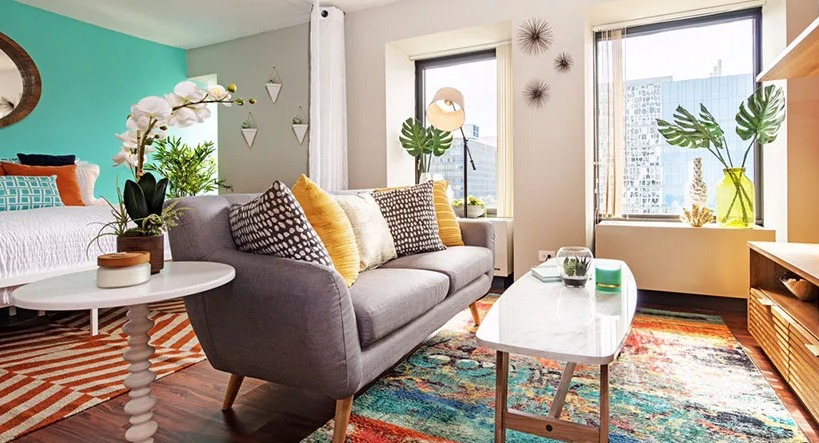 A stylish studio apartment at Axis Apartments & Lofts in Chicago, complete with a cozy living area and large windows