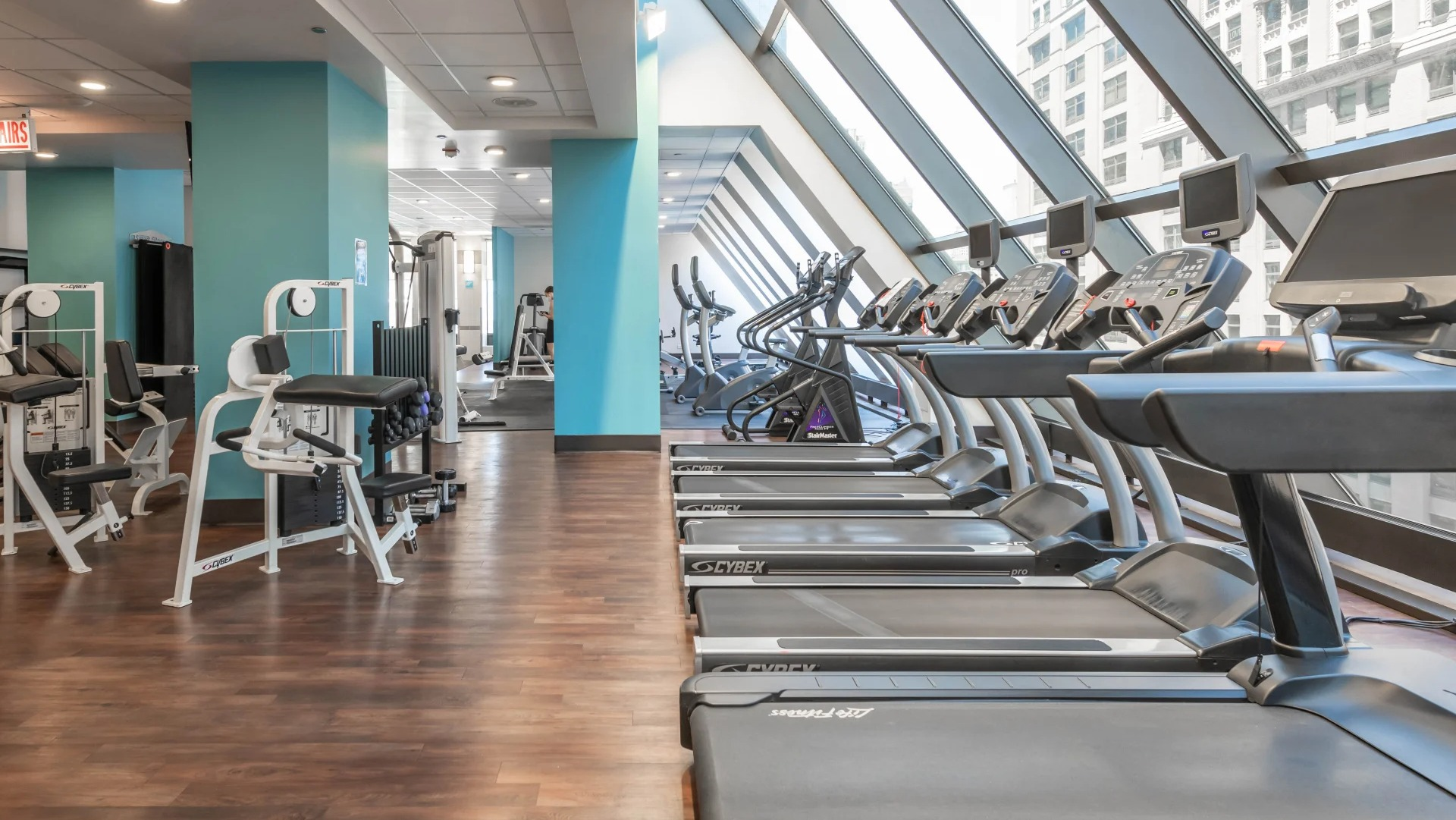 Rows of treadmills and weight machines in the modern fitness center at Axis Apartments & Lofts in Chicago