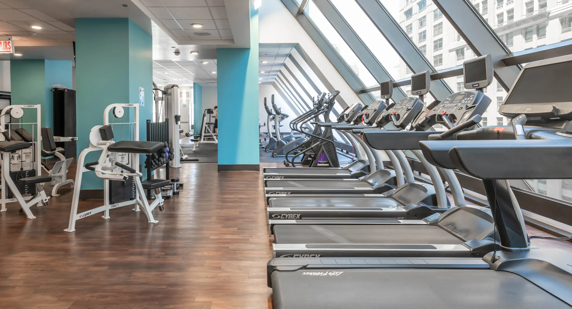Rows of treadmills and weight machines in the modern fitness center at Axis Apartments & Lofts in Chicago