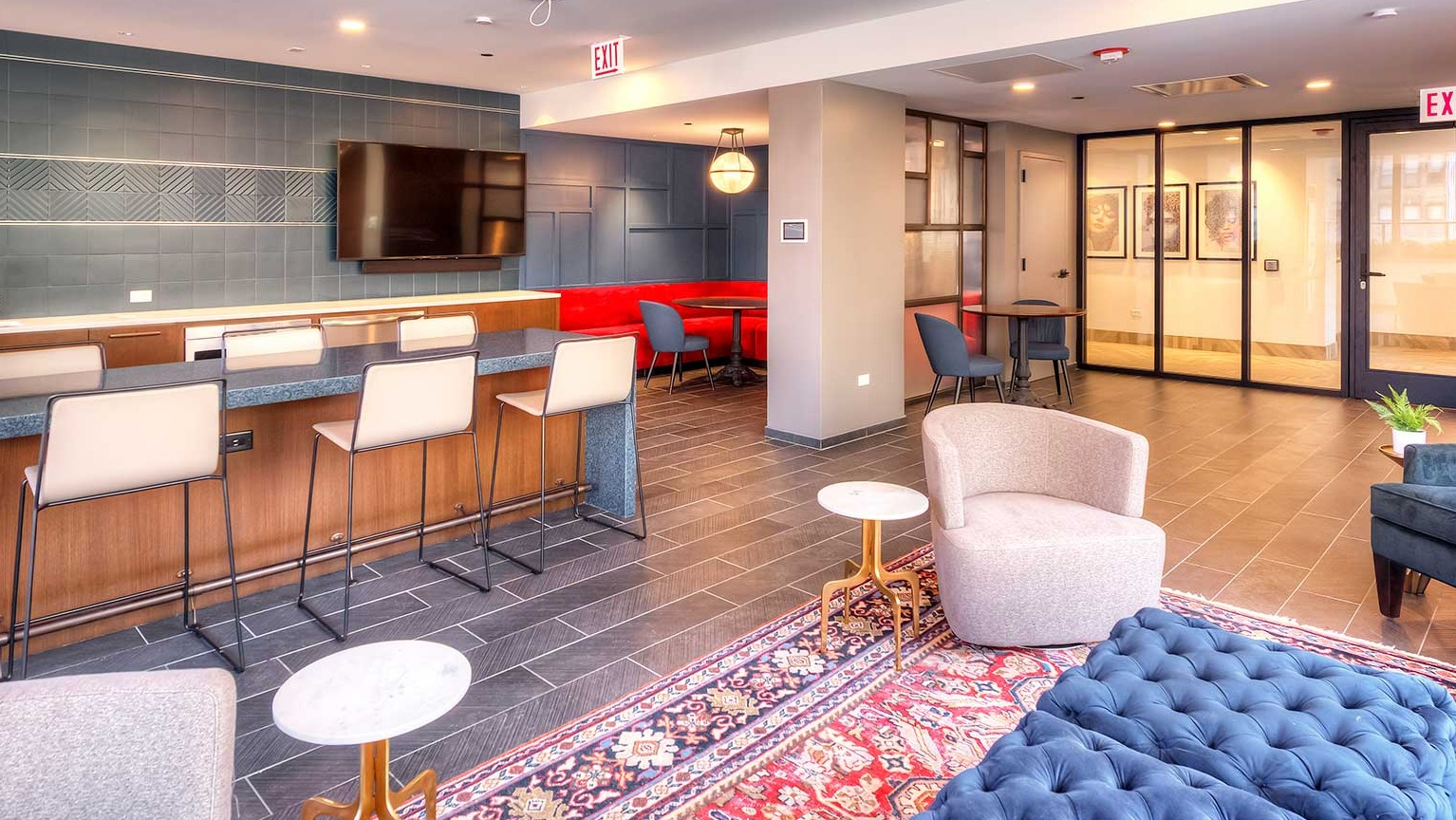 Contemporary community lounge with a large bar area, stylish seating, and a TV, ideal for social gatherings at Burnham Pointe apartments in Chicago