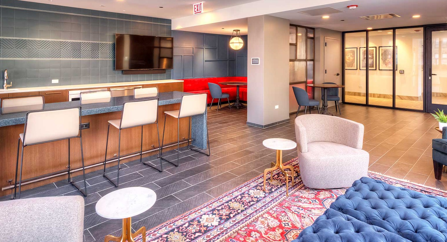 Contemporary community lounge with a large bar area, stylish seating, and a TV, ideal for social gatherings at Burnham Pointe apartments in Chicago