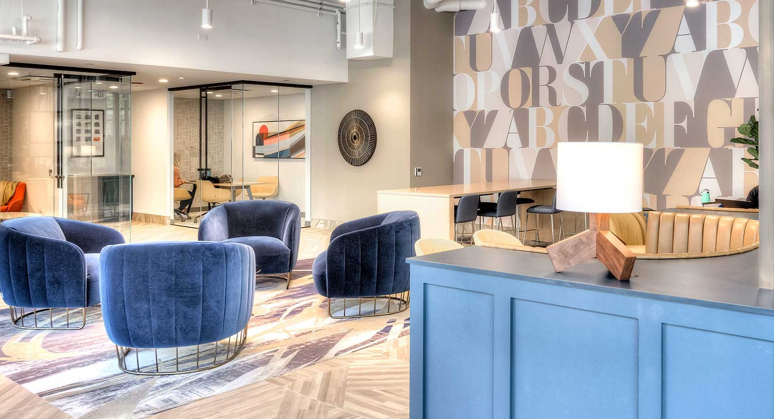 Modern coworking space and lobby area with diverse seating arrangements and large windows, at Burnham Pointe apartments in Chicago