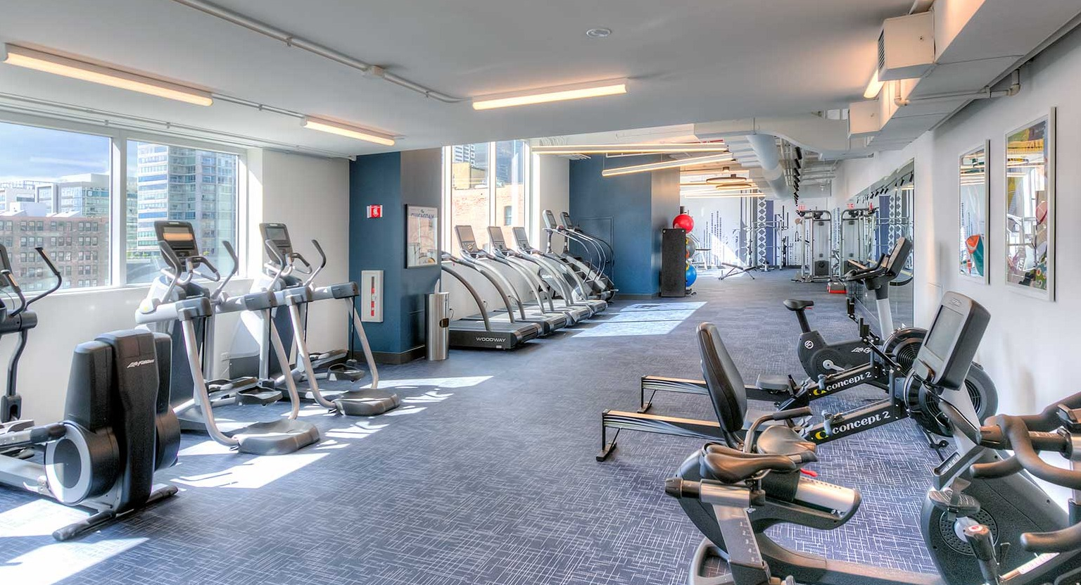 Modern fitness center featuring a wide array of cardio machines including treadmills and ellipticals, at Burnham Pointe apartments in Chicago