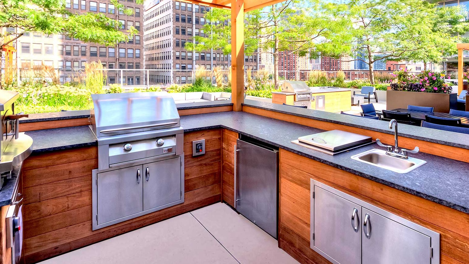 Fully equipped outdoor grill and kitchen area under a pergola, perfect for al fresco dining at Burnham Pointe apartments in Chicago