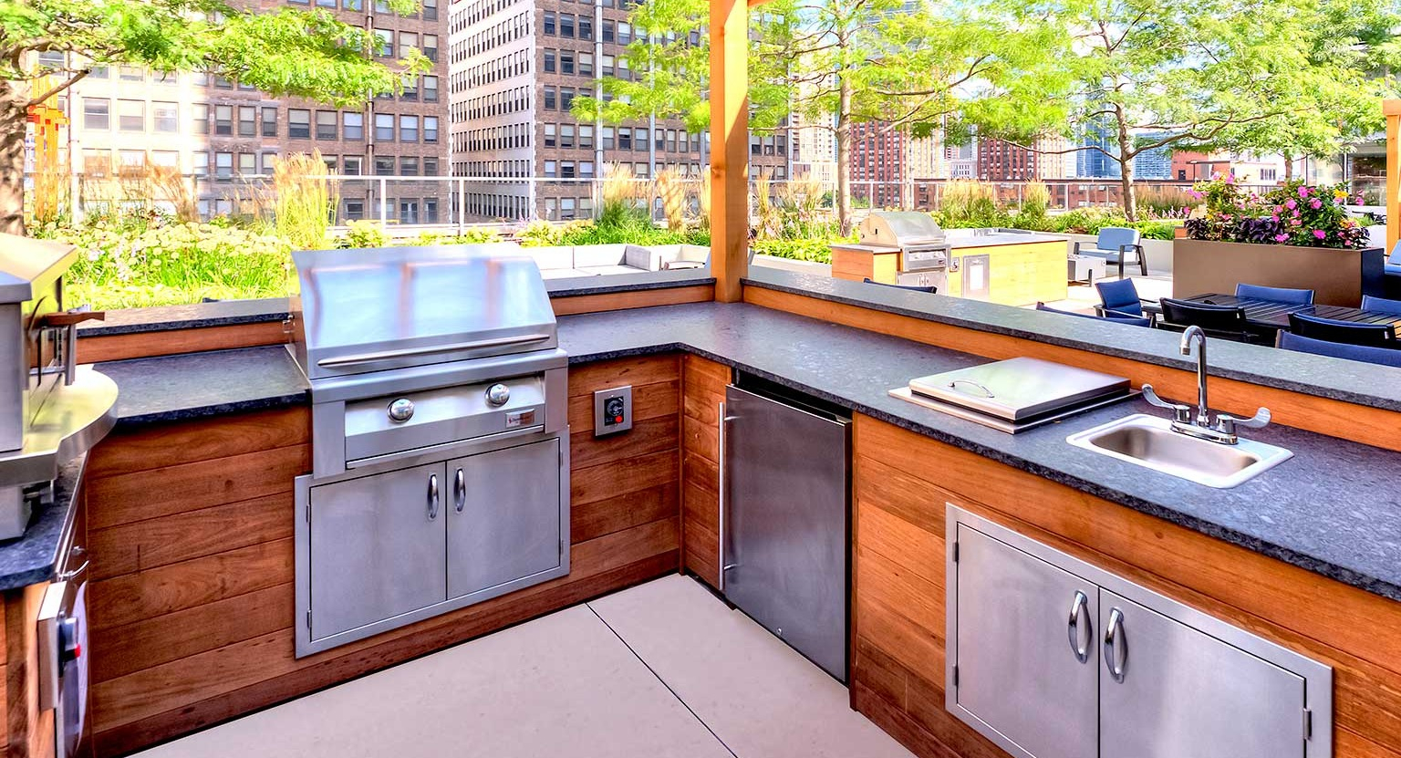 Fully equipped outdoor grill and kitchen area under a pergola, perfect for al fresco dining at Burnham Pointe apartments in Chicago