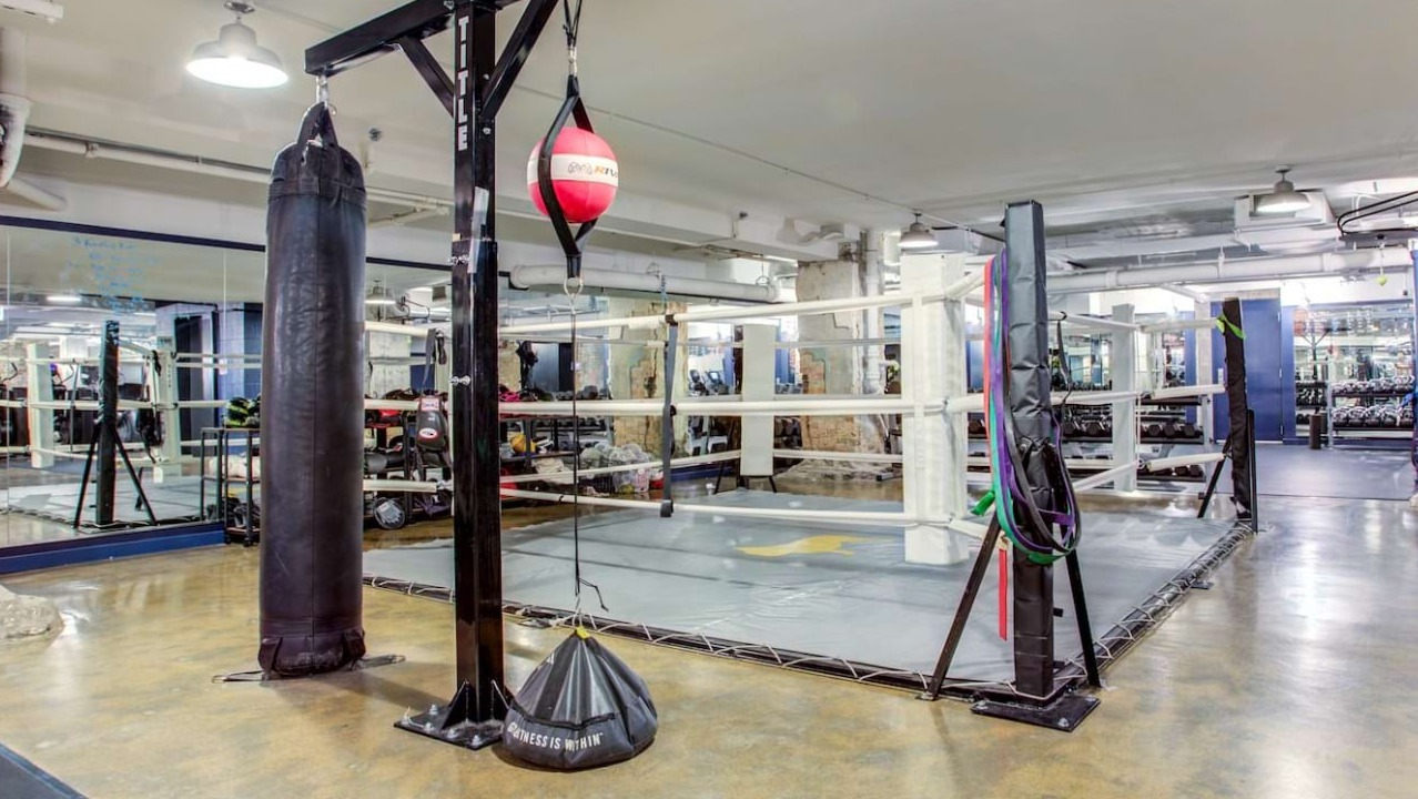 Unique boxing gym at The Bush Temple in Chicago, featuring a full-size boxing ring, punching bags, and industrial-chic decor