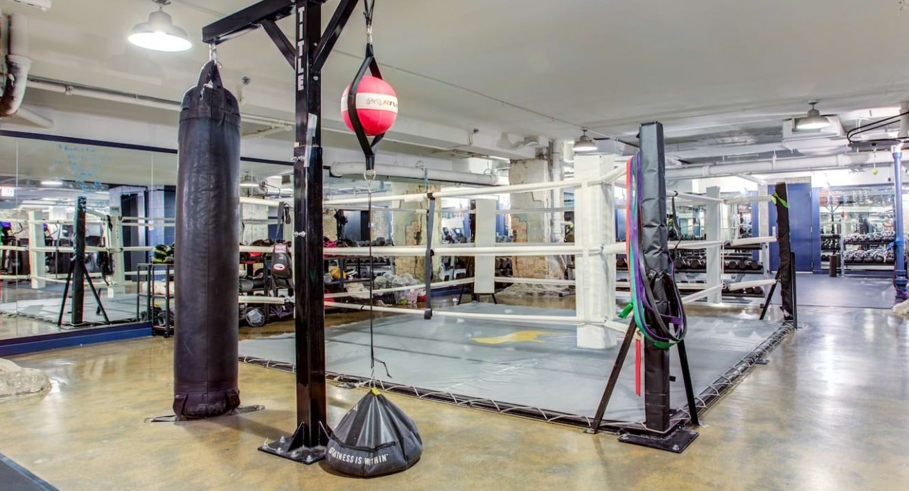 Unique boxing gym at The Bush Temple in Chicago, featuring a full-size boxing ring, punching bags, and industrial-chic decor