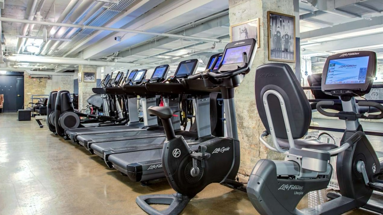 Well-equipped cardio room at The Bush Temple in Chicago, featuring treadmills, ellipticals, and exercise bikes