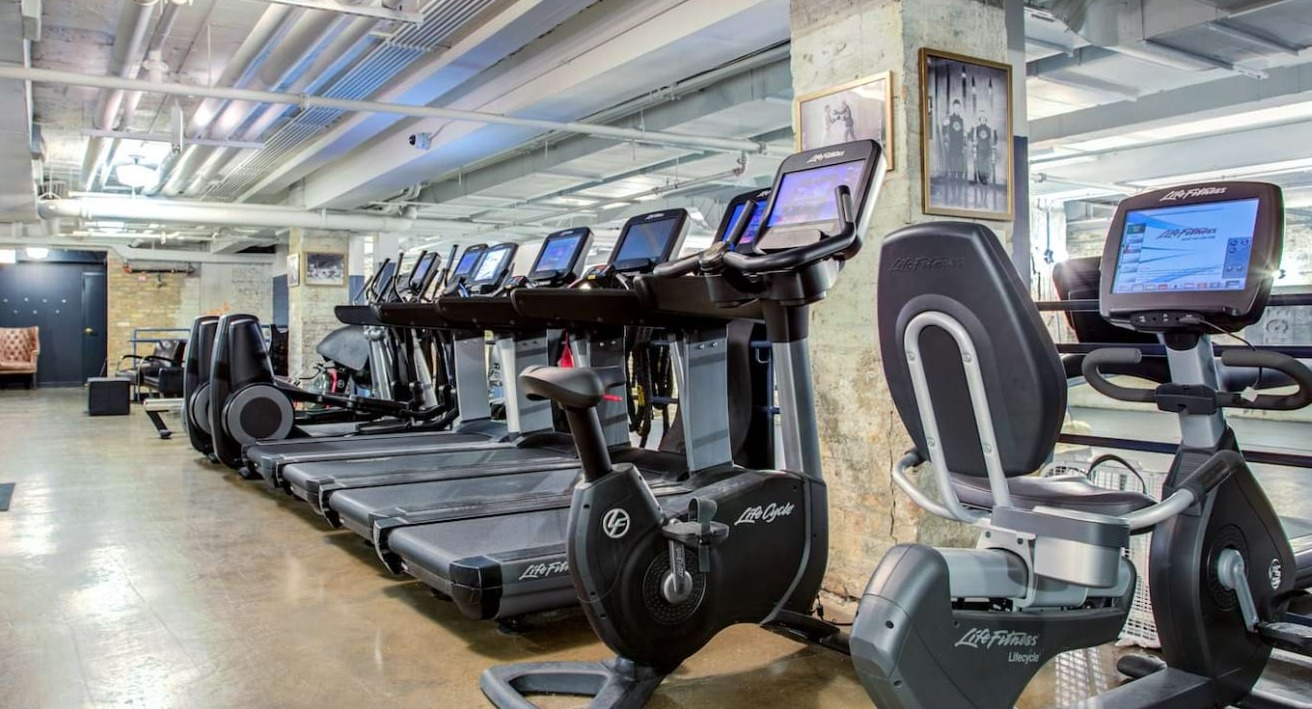 Well-equipped cardio room at The Bush Temple in Chicago, featuring treadmills, ellipticals, and exercise bikes