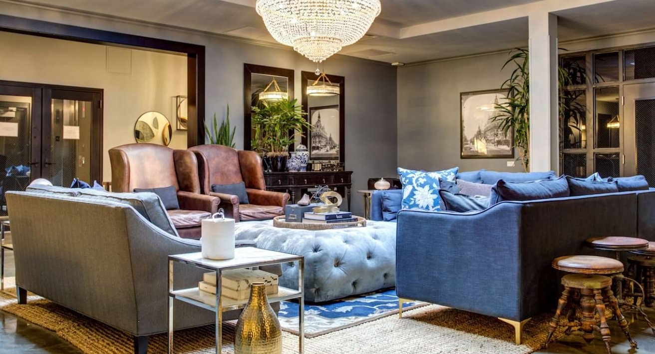 Grand and stylish resident lounge at The Bush Temple in Chicago, featuring plush sofas, a large chandelier, and a cozy atmosphere