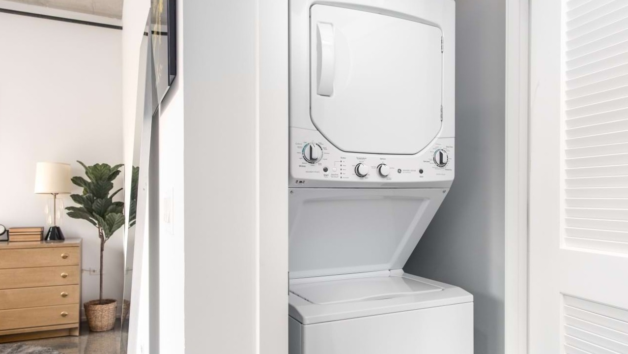 Convenient in-unit stacked washer and dryer at The Bush Temple in Chicago, located near a bedroom for easy access