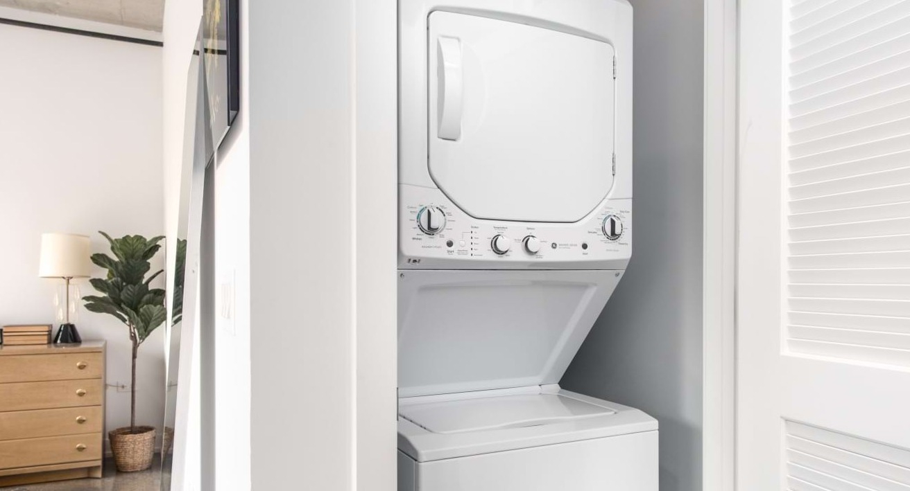 Convenient in-unit stacked washer and dryer at The Bush Temple in Chicago, located near a bedroom for easy access