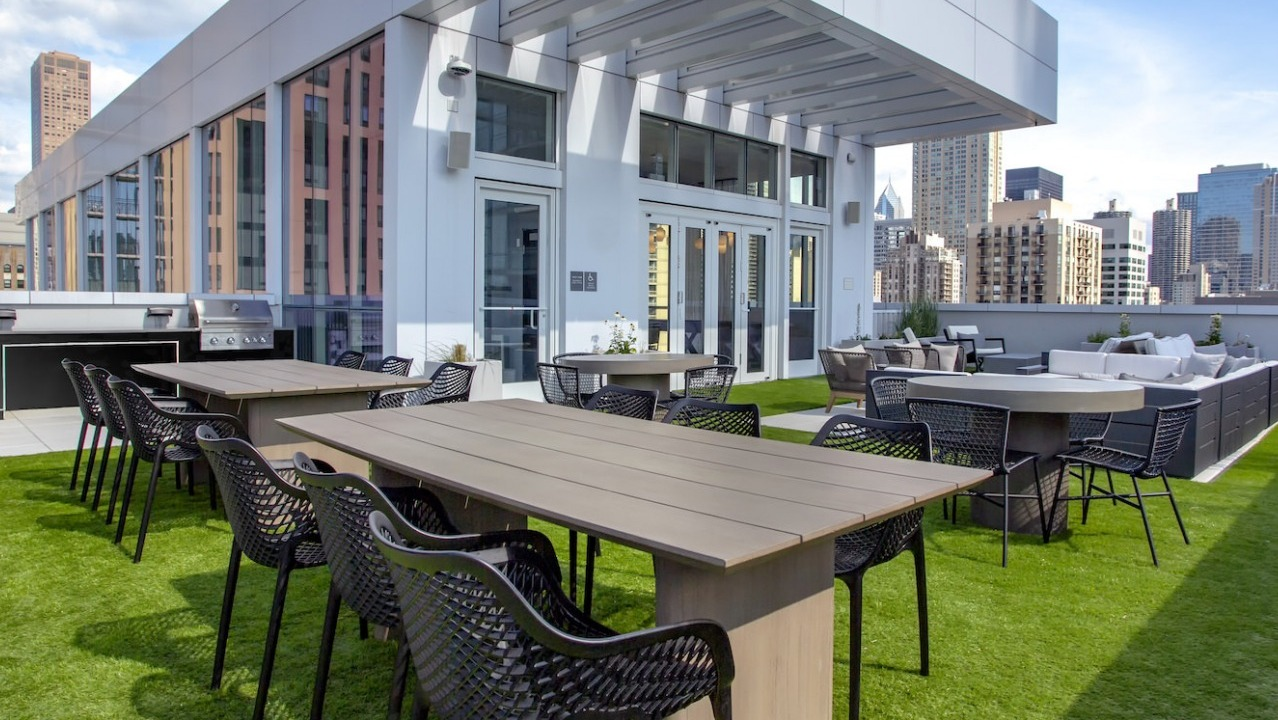 Expansive rooftop grilling and lounge area at The Bush Temple in Chicago, featuring outdoor dining tables and comfortable seating