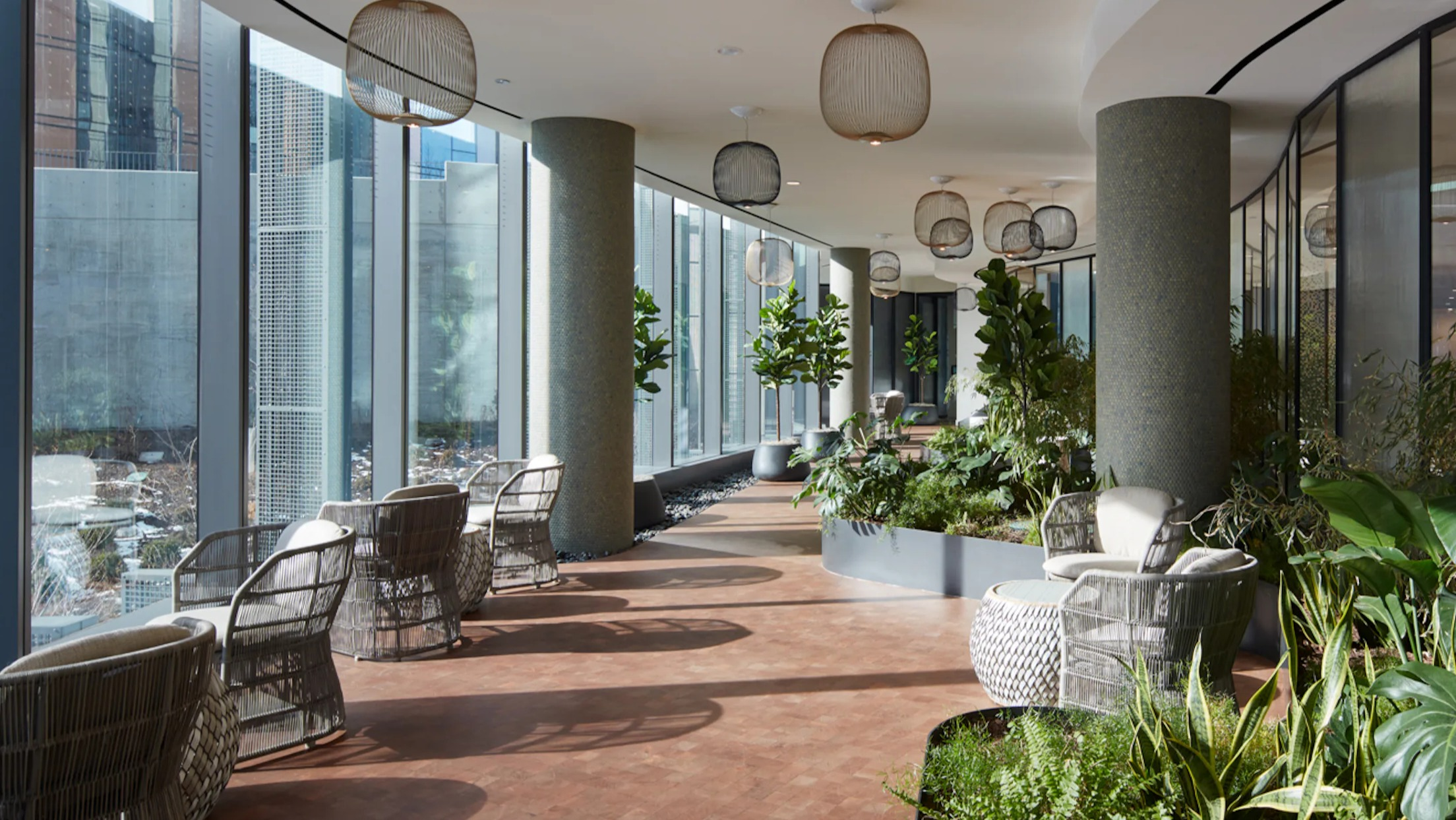 Serene indoor garden lounge with modern seating, abundant greenery, and large windows at Cascade Lakeshore East in Chicago