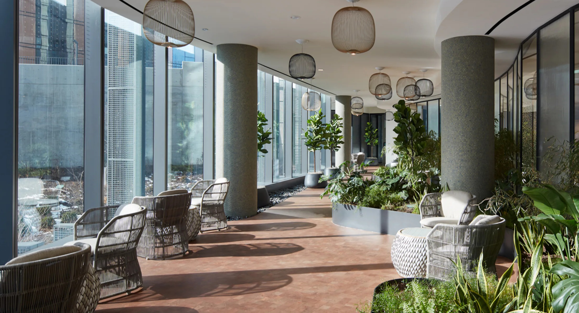 Serene indoor garden lounge with modern seating, abundant greenery, and large windows at Cascade Lakeshore East in Chicago