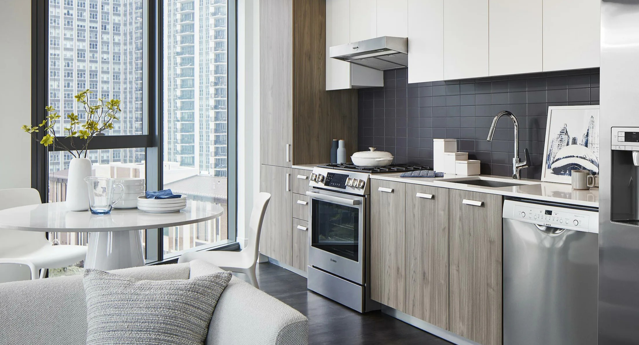 Contemporary kitchen with stainless steel appliances and a dining nook, perfect for small meals at Cascade Lakeshore East in Chicago