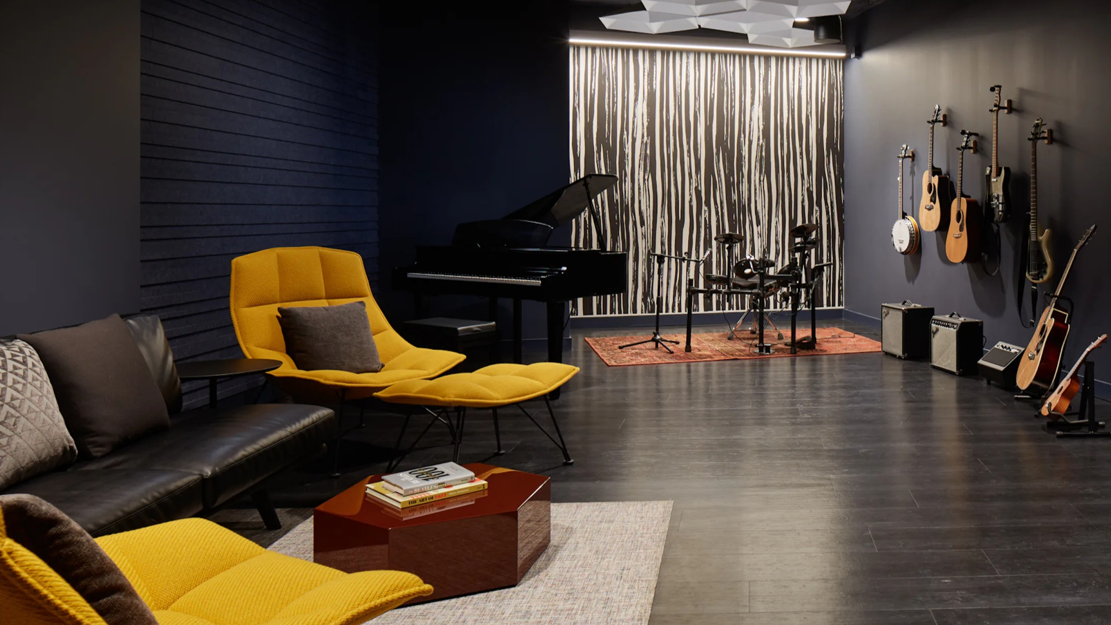 Dedicated music studio with a grand piano, drum set, and guitars for residents' creative pursuits at Cascade Lakeshore East in Chicago