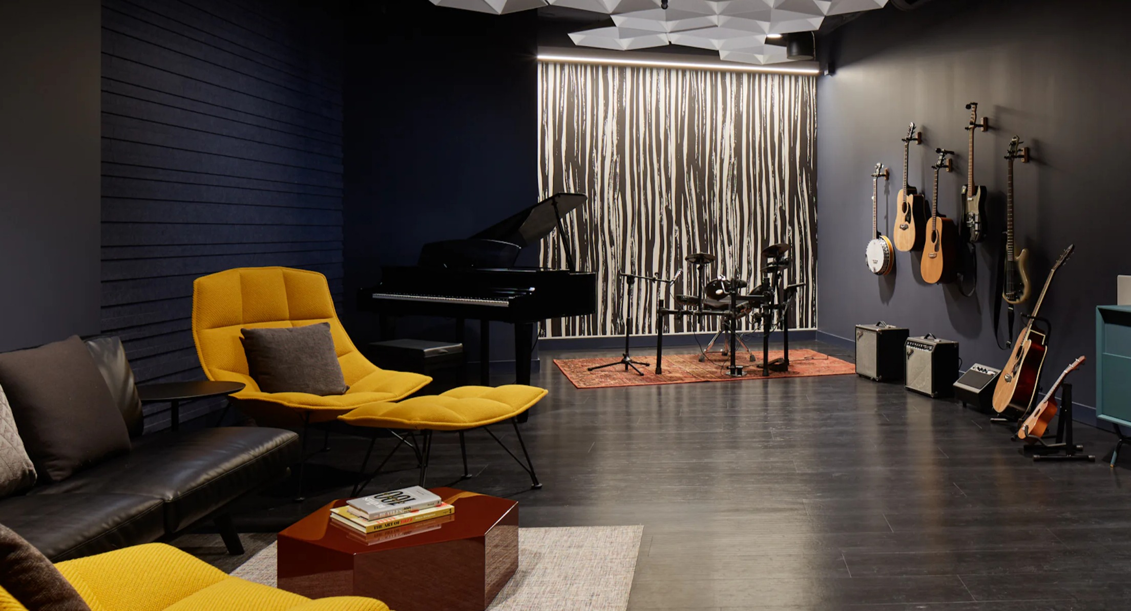 Dedicated music studio with a grand piano, drum set, and guitars for residents' creative pursuits at Cascade Lakeshore East in Chicago