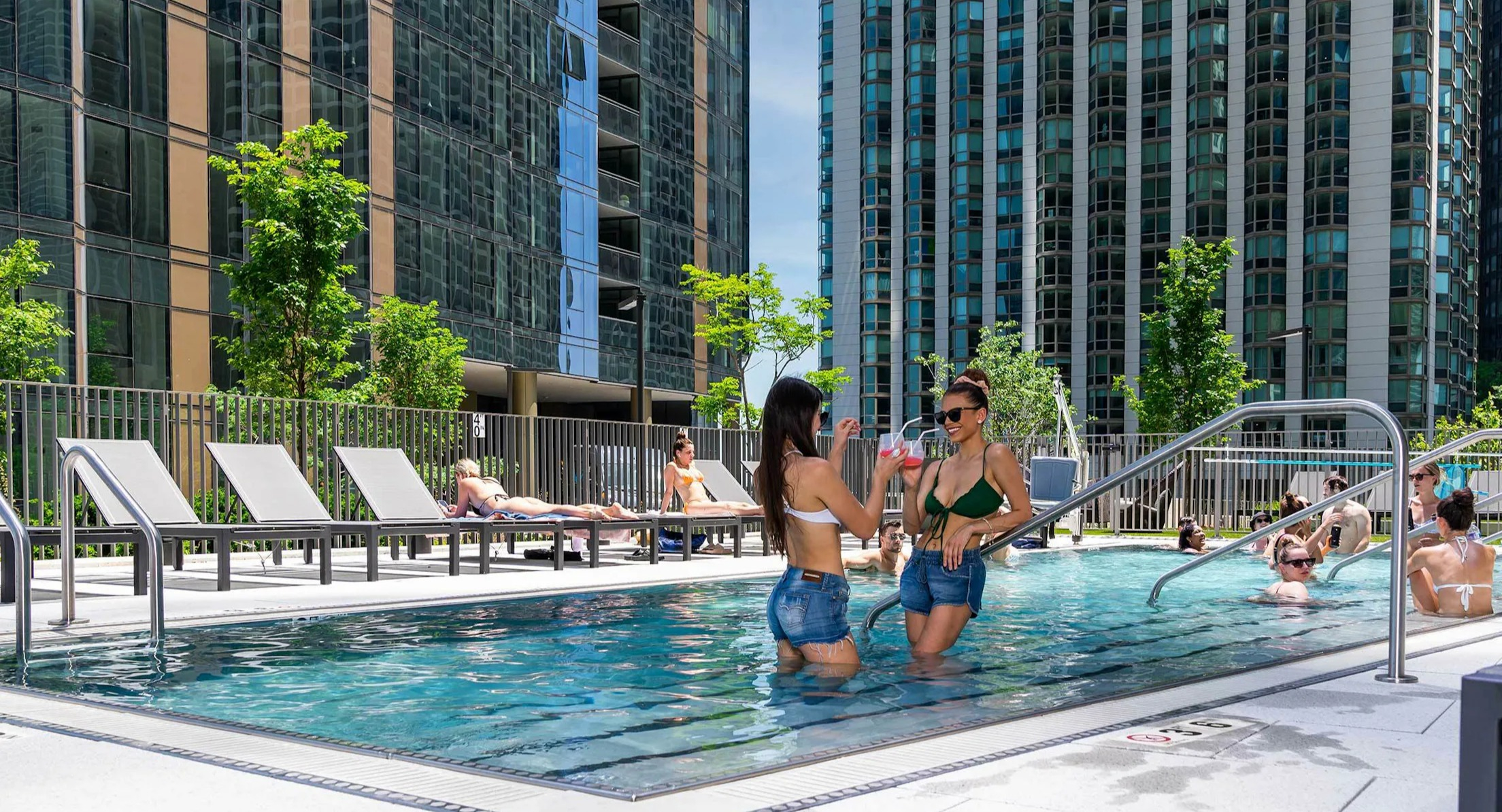 Vibrant outdoor swimming pool with residents enjoying the sun and water, surrounded by modern buildings in Chicago