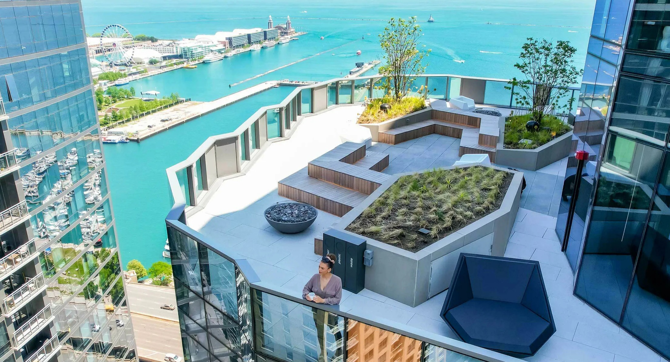 Rooftop deck with stunning lake and city views, featuring seating areas and landscaping at Cascade Lakeshore East in Chicago