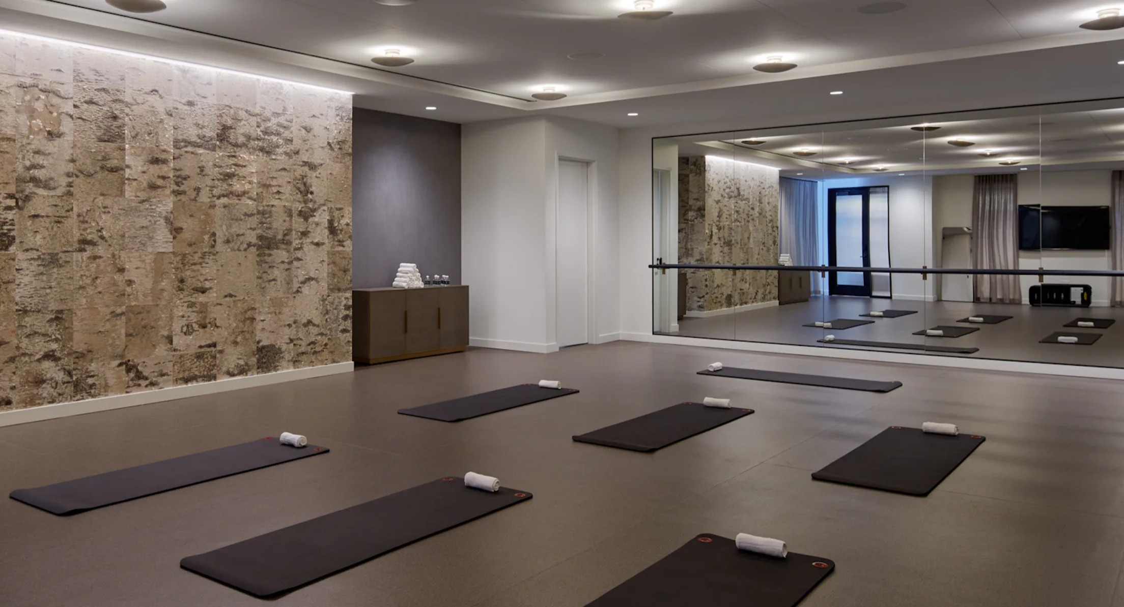Spacious yoga and meditation studio with exercise mats and a ballet barre at Cascade Lakeshore East in Chicago