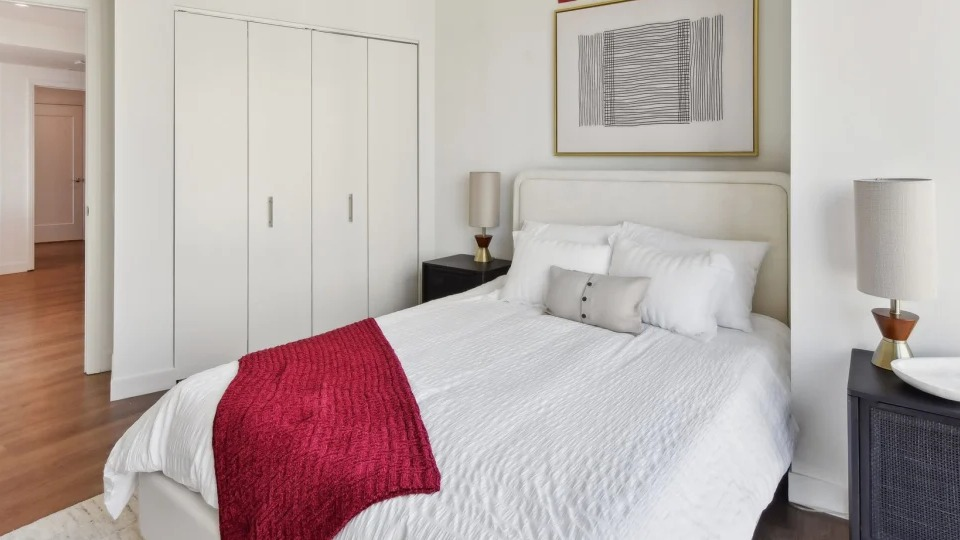 Cozy apartment bedroom with a comfortable bed, stylish nightstands, and a spacious closet at Cassidy on Canal apartments in Chicago