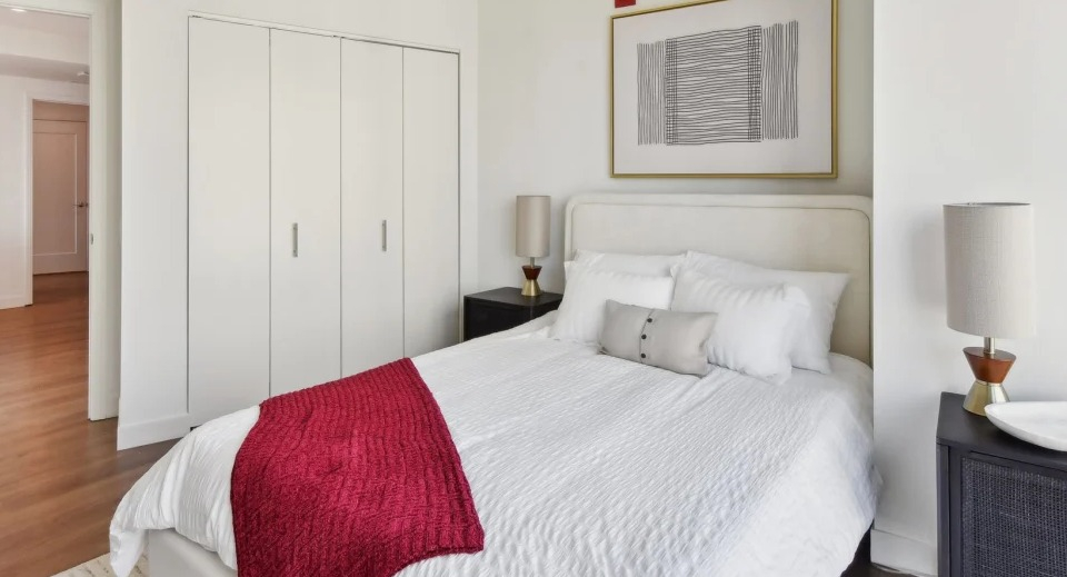 Cozy apartment bedroom with a comfortable bed, stylish nightstands, and a spacious closet at Cassidy on Canal apartments in Chicago