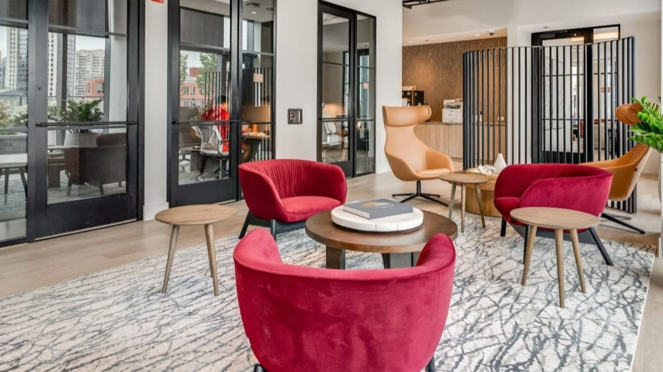 Inviting and modern lobby seating area with plush red armchairs and warm decor, perfect for welcoming guests at Cassidy on Canal in Chicago