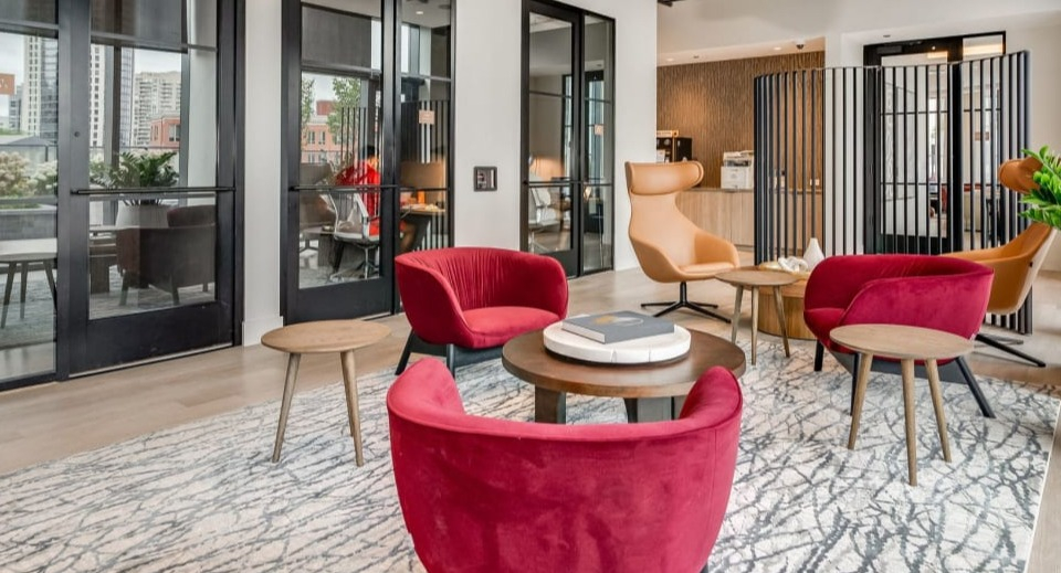 Inviting and modern lobby seating area with plush red armchairs and warm decor, perfect for welcoming guests at Cassidy on Canal in Chicago