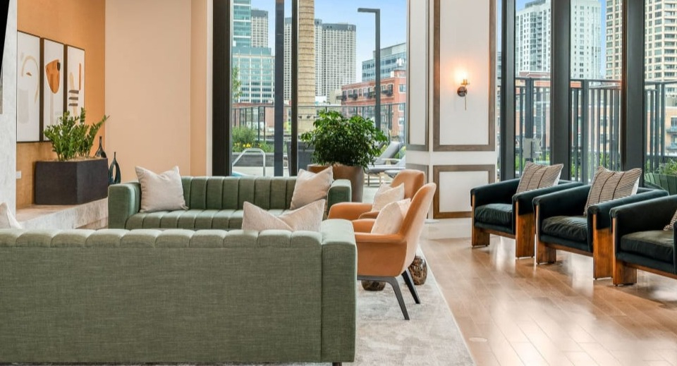 Elegant resident lounge with modern furnishings, a stylish fireplace, and expansive windows overlooking the city at Cassidy on Canal in Chicago
