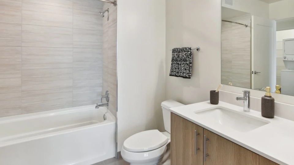 Bright and modern apartment bathroom with a bathtub, sleek vanity, and contemporary fixtures at Cassidy on Canal apartments in Chicago
