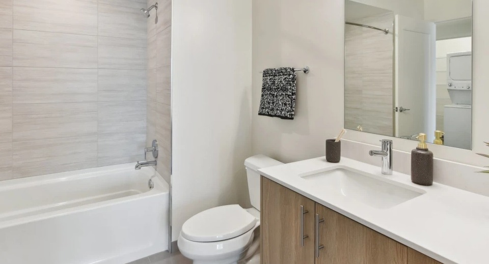 Bright and modern apartment bathroom with a bathtub, sleek vanity, and contemporary fixtures at Cassidy on Canal apartments in Chicago
