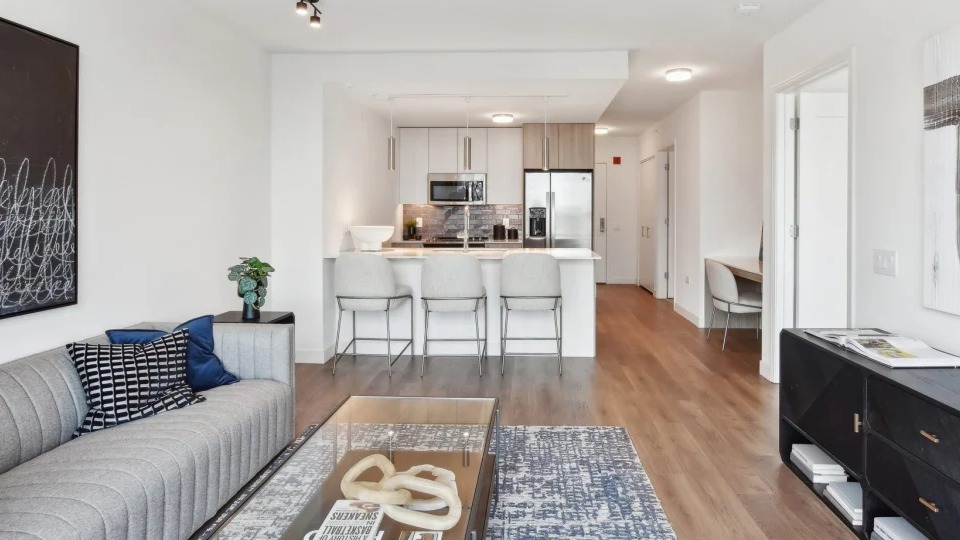 Contemporary open-layout apartment featuring a stylish living room connected to a modern kitchen with a breakfast bar at Cassidy on Canal in Chicago