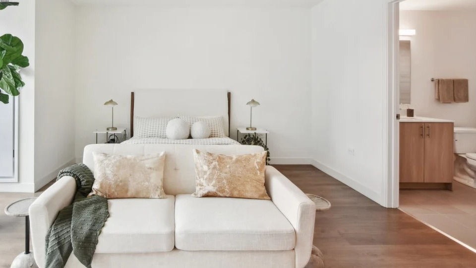 Serene master bedroom with a comfortable bed, large windows, and an ensuite bathroom entry at Cassidy on Canal apartments in Chicago
