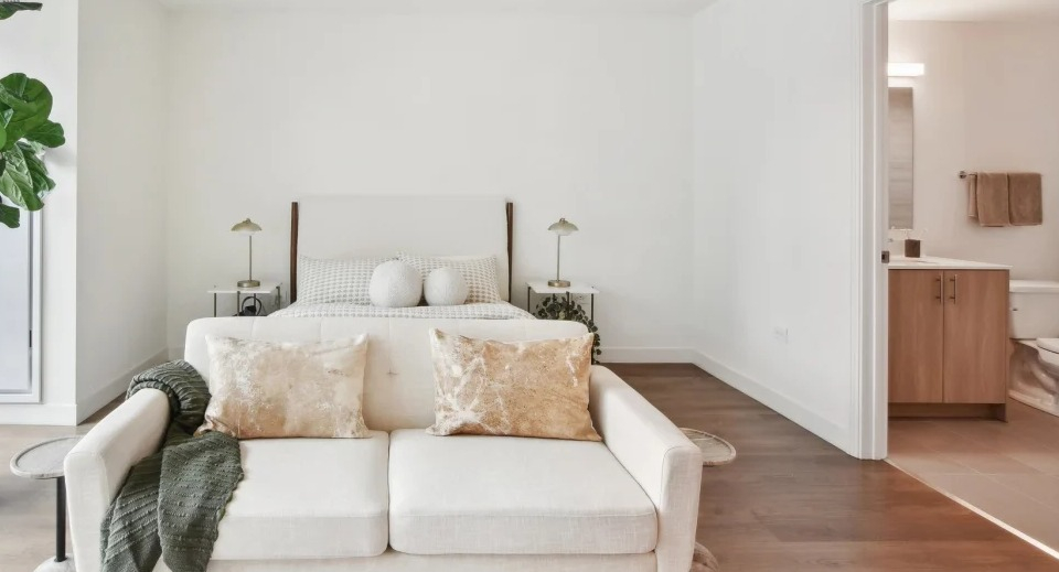 Serene master bedroom with a comfortable bed, large windows, and an ensuite bathroom entry at Cassidy on Canal apartments in Chicago
