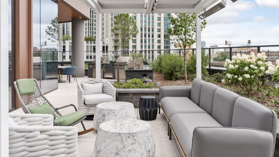Inviting outdoor lounge area with modern sofas, comfortable chairs, and stylish tables, ideal for relaxation at Cassidy on Canal apartments in Chicago