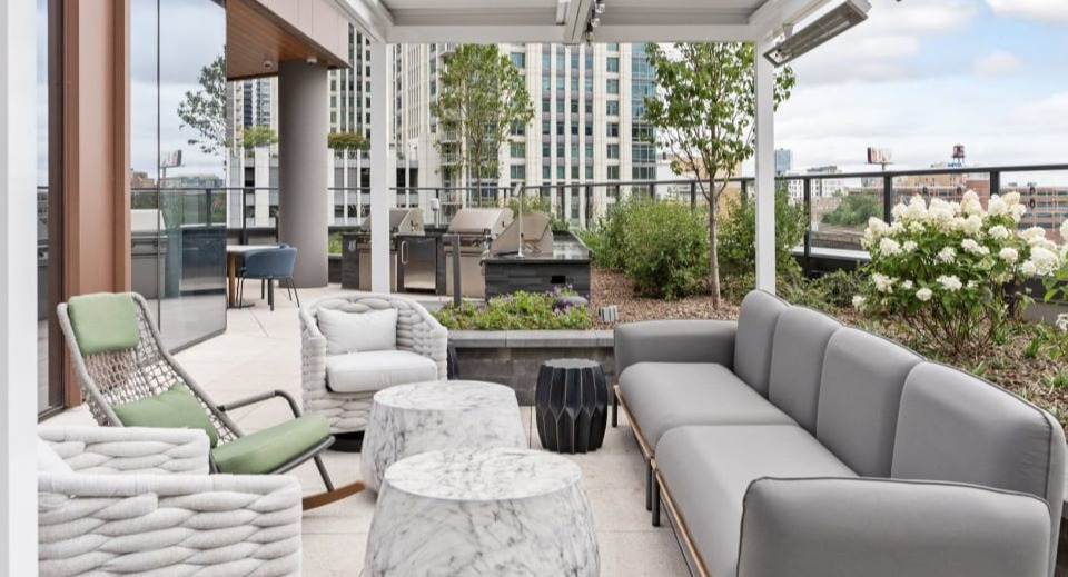 Inviting outdoor lounge area with modern sofas, comfortable chairs, and stylish tables, ideal for relaxation at Cassidy on Canal apartments in Chicago