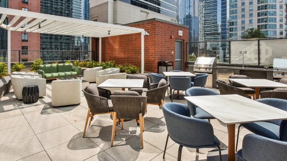 Vibrant outdoor patio area with multiple grilling stations, diverse seating arrangements, and urban city views at Cassidy on Canal in Chicago