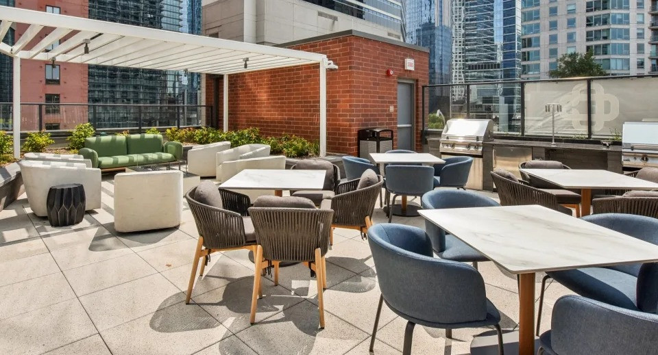 Vibrant outdoor patio area with multiple grilling stations, diverse seating arrangements, and urban city views at Cassidy on Canal in Chicago